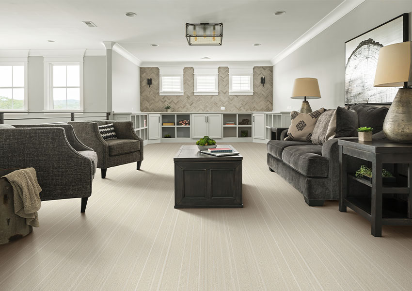 cream pattern carpet in living room with grey couch and chairs