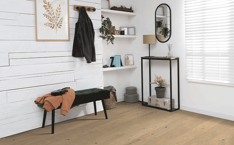 warm toned hardwood flooring in entryway with storage